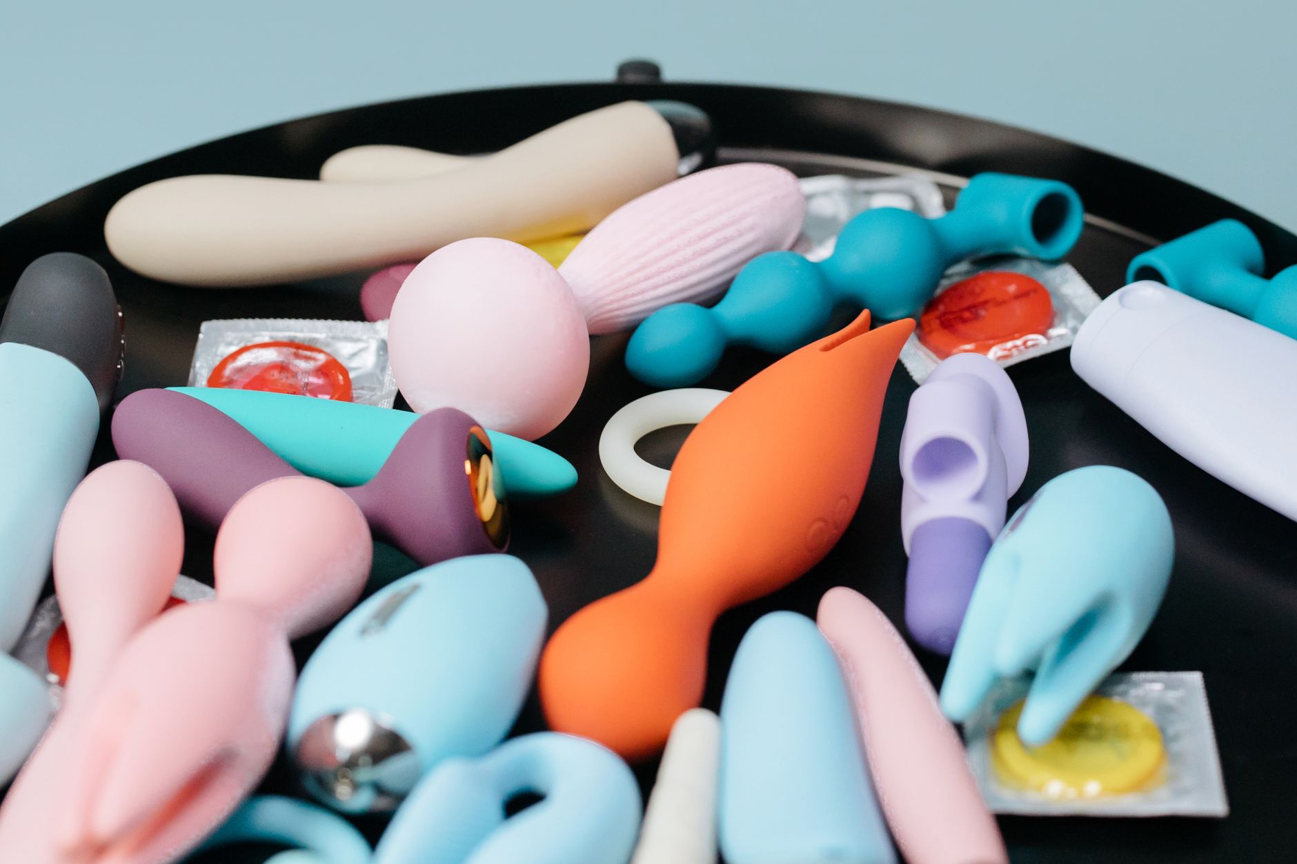A vibrant collection of various lemon vibrators and clitoral toys on a black surface, featuring diverse shapes and colors