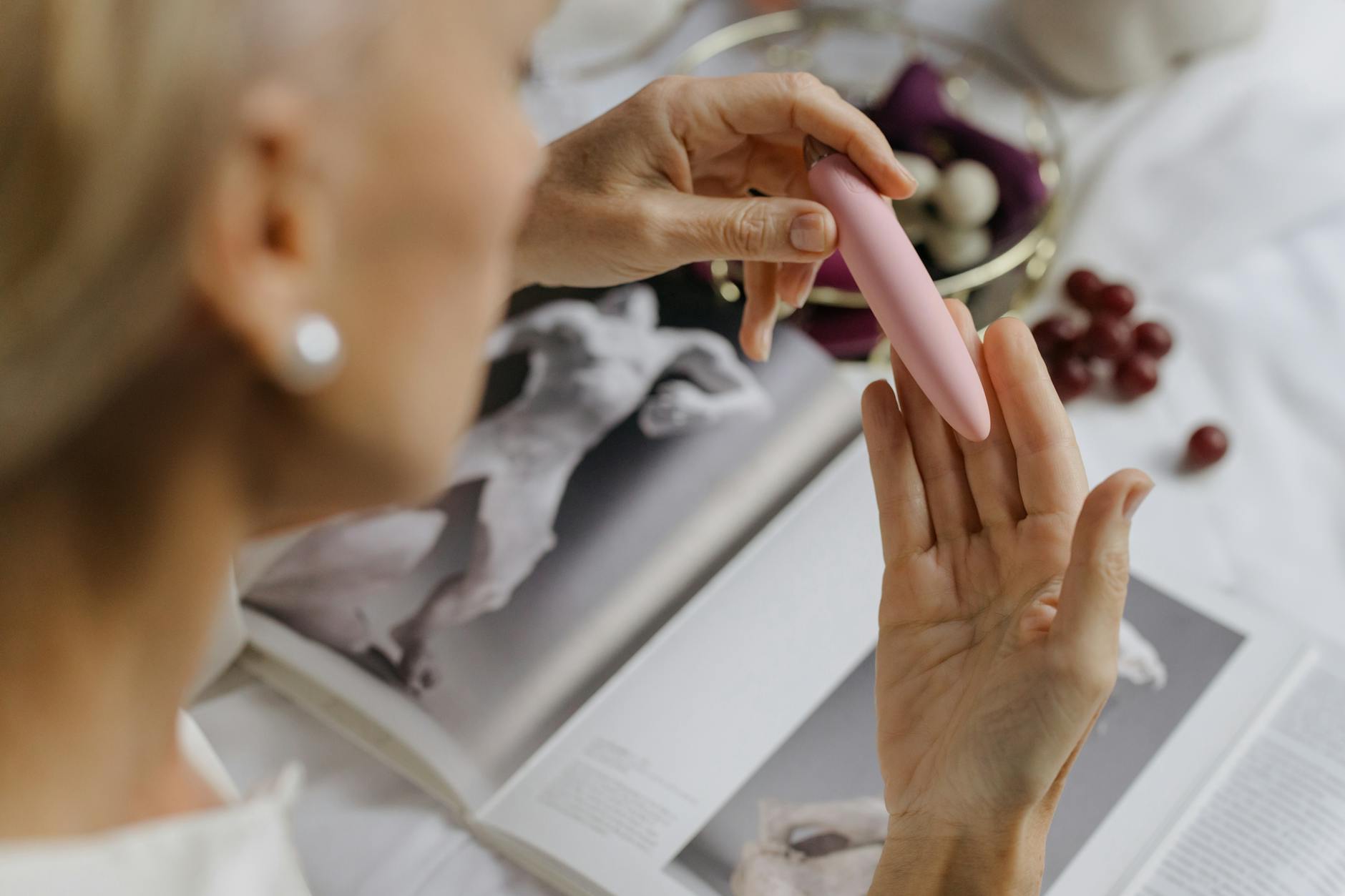 Close-up of hands holding a pink vibrator, emphasizing personal intimacy and pleasure exploration