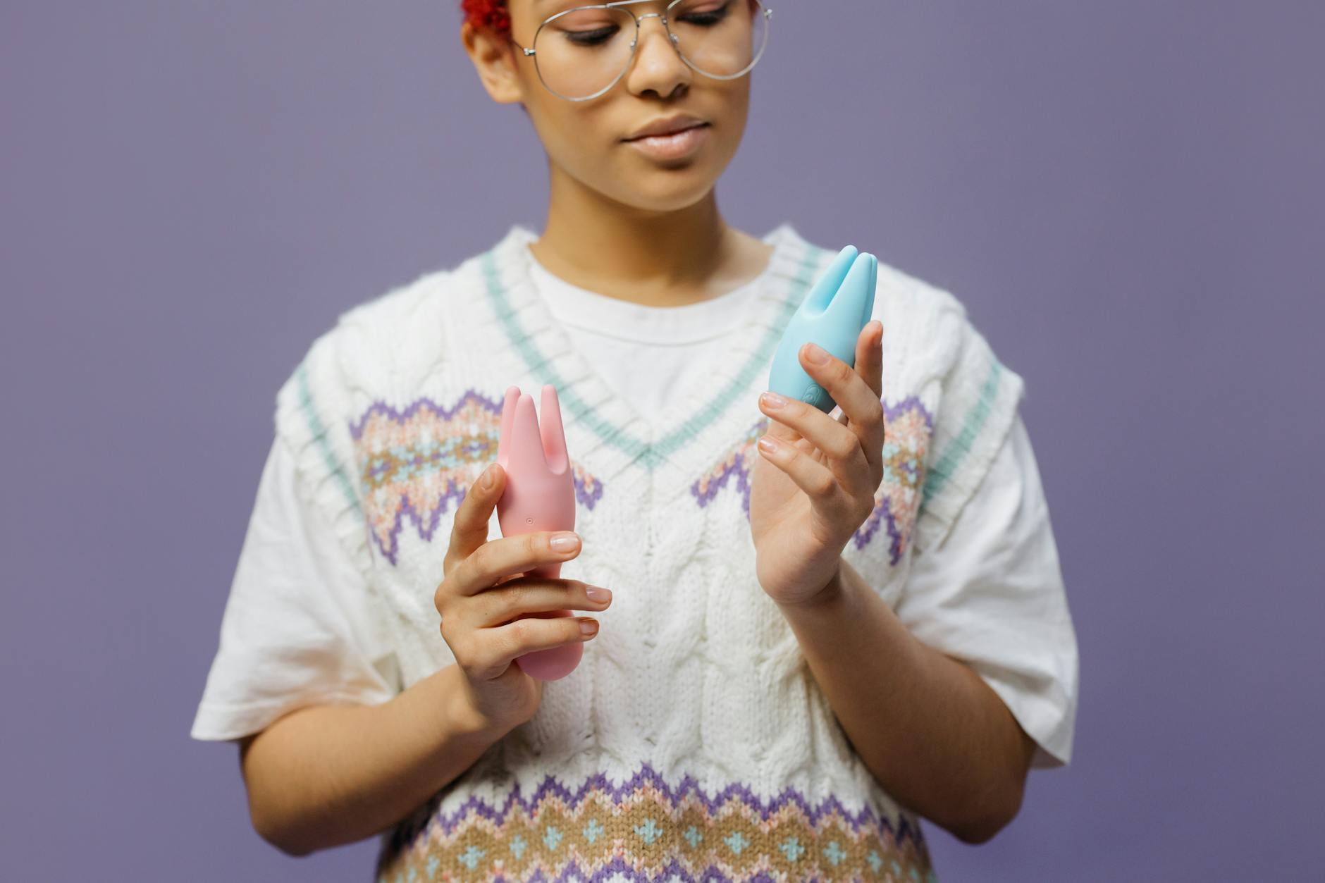 Woman holding a blue personal massager in a contemplative manner, representing vulnerable communication with a new partner.