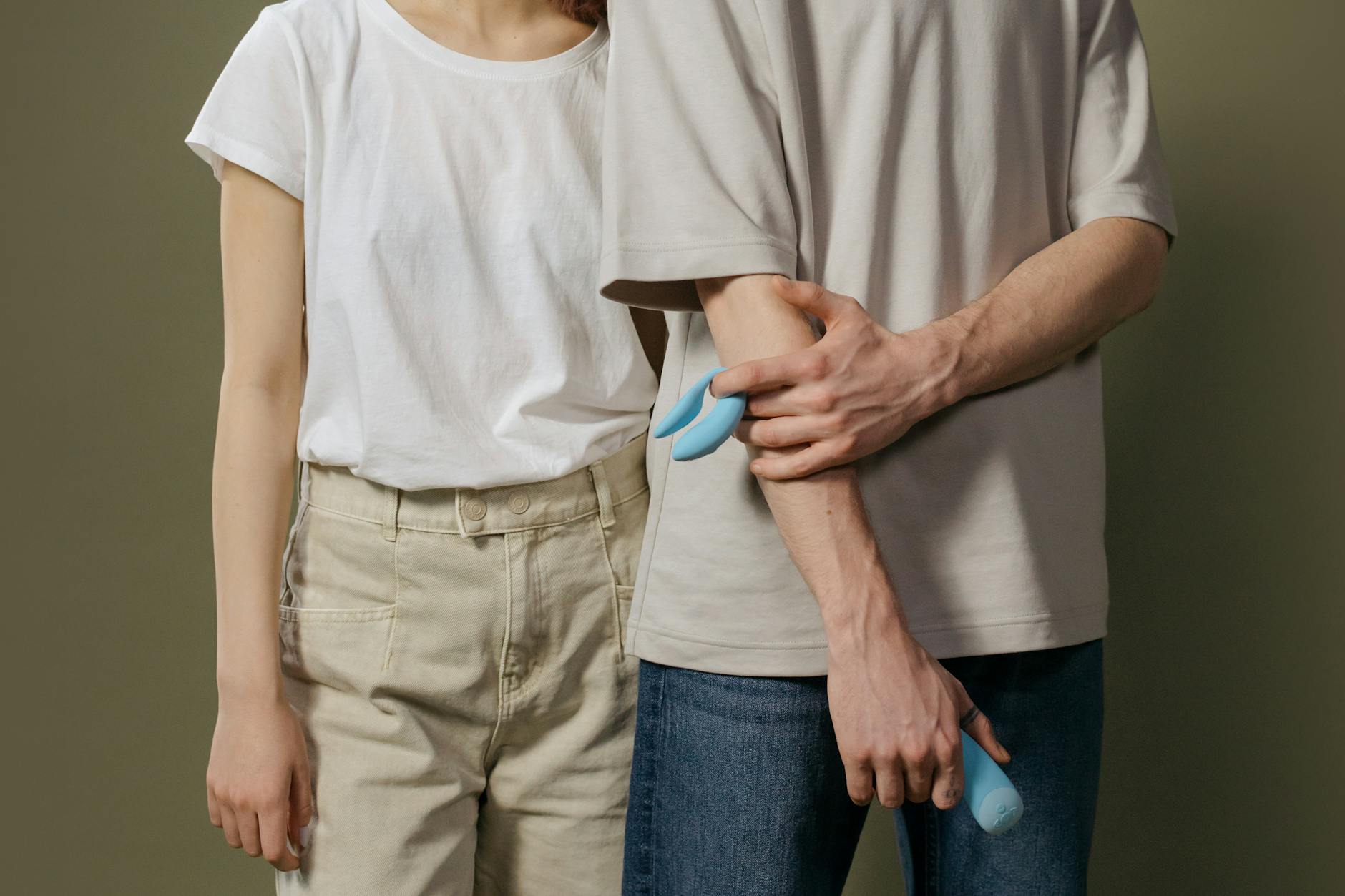 A teal suction vibrator on white silk fabric, representing personalized pleasure settings