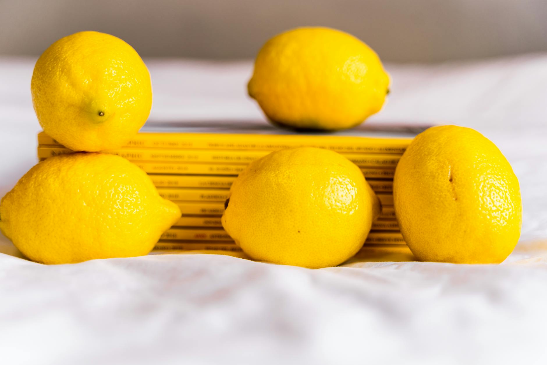 Yellow silicone vibrator surrounded by peeled bananas on yellow background